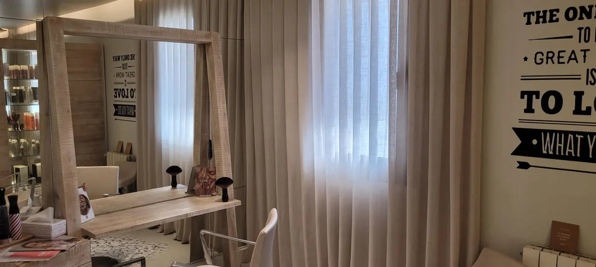 Puesto de trabajo con espejo, luz natural y cortinas en tonos crema